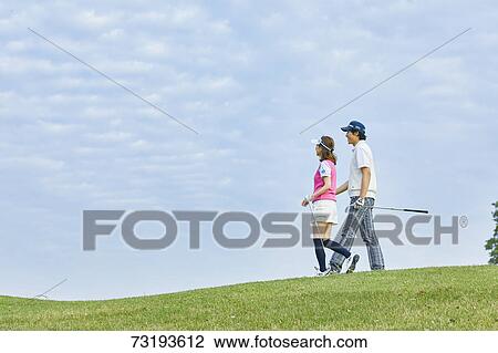 Stock Image - Japanese golf players on course. Fotosearch