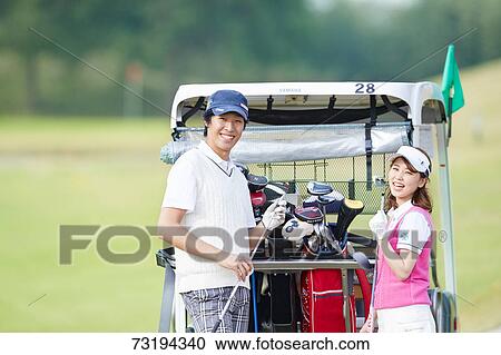 Stock Image - Japanese golf players on course. Fotosearch
