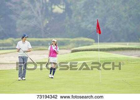 Stock Image - Japanese golf players on course. Fotosearch