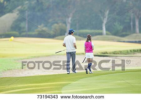 Stock Image - Japanese golf players on course. Fotosearch