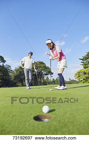 Stock Photo - Japanese golf players on course. Fotosearch