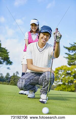 Stock Photograph - Japanese golf players on course. Fotosearch