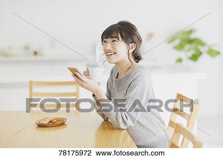 Stock Image - Japanese housewife in the kitchen. Fotosearch