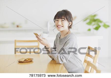 Stock Image - Japanese housewife in the kitchen. Fotosearch