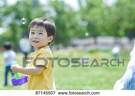 Stock Photo - Japanese kid in a city park. Fotosearch