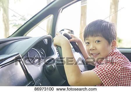 Stock Image - Japanese kid in the car. Fotosearch