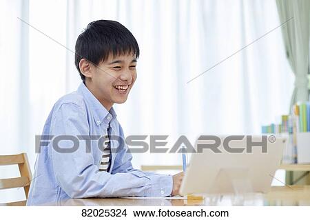Picture - Japanese kid studying at home. Fotosearch