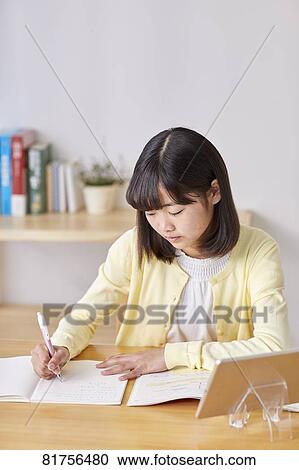 Stock Image - Japanese kid studying at home. Fotosearch