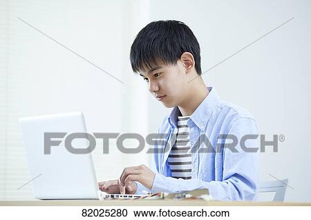 Stock Image - Japanese kid studying at home. Fotosearch