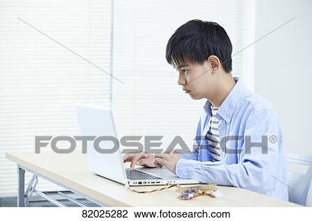 Stock Image - Japanese kid studying at home. Fotosearch