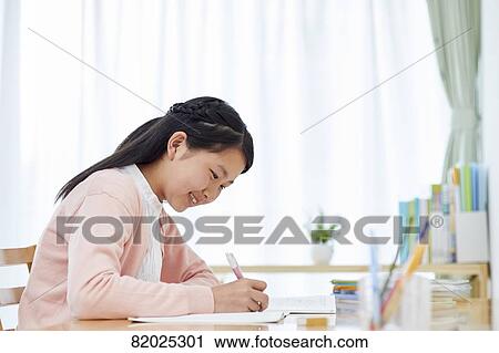 Stock Image - Japanese kid studying at home. Fotosearch