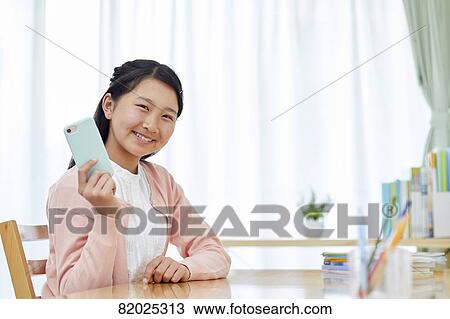 Stock Image - Japanese kid studying at home. Fotosearch