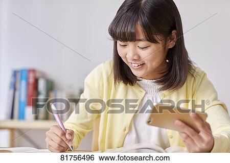 Stock Photograph - Japanese kid studying at home. Fotosearch