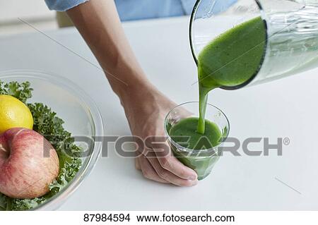 Picture - Japanese man making smoothie in the kitchen. Fotosearch
