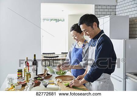 Stock Image - Japanese mature couple in the kitchen. Fotosearch