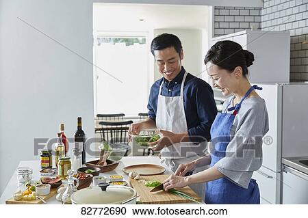 Stock Image - Japanese mature couple in the kitchen. Fotosearch