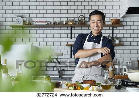 Picture - Japanese mature man in the kitchen. Fotosearch