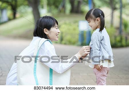Picture - Japanese mother and daughter at a city park. Fotosearch
