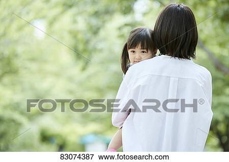 Stock Photo - Japanese mother and daughter at a city park. Fotosearch