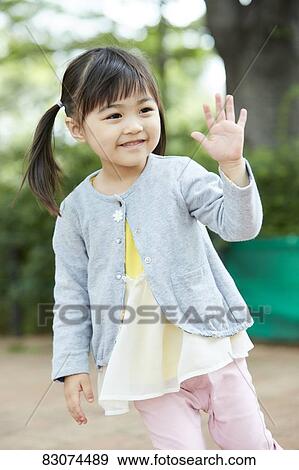 Stock Photo - Japanese mother and daughter at a city park. Fotosearch
