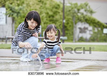 Japanese mother and daughter at a city park View Large Photo Image Stock Photograph - Japanese mother and daughter at a city park. Fotosearch