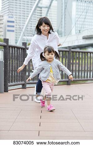 Stock Photography - Japanese mother and daughter at a city park. Fotosearch