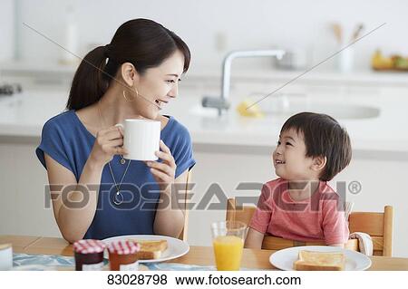 Stock Photo - Japanese mother and kid having breakfast. Fotosearch