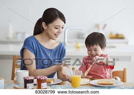 Stock Photo - Japanese mother and kid having breakfast. Fotosearch