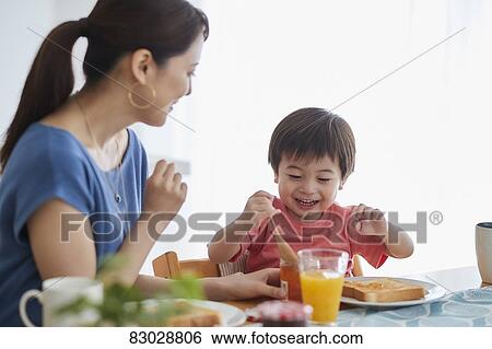 Stock Photograph - Japanese mother and kid having breakfast. Fotosearch