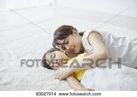 Picture - Japanese mother with sleeping kid. Fotosearch
