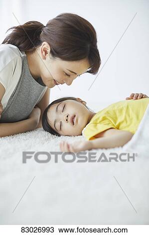 Stock Image - Japanese mother with sleeping kid. Fotosearch