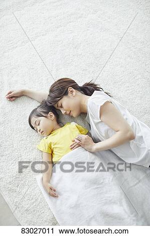 Stock Image - Japanese mother with sleeping kid. Fotosearch
