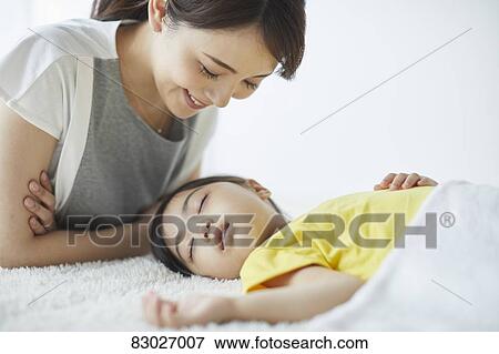 Stock Photo - Japanese mother with sleeping kid. Fotosearch