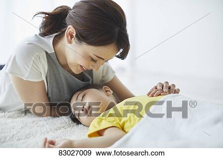 Japanese mother with sleeping kid View Large Photo Image Stock Photo - Japanese mother with sleeping kid. Fotosearch