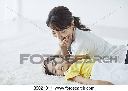Stock Photo - Japanese mother with sleeping kid. Fotosearch