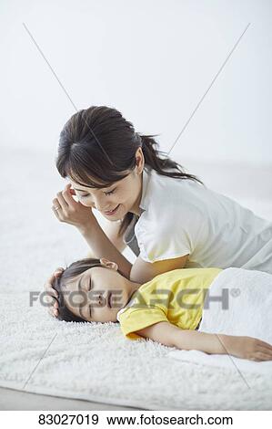 Stock Photo - Japanese mother with sleeping kid. Fotosearch