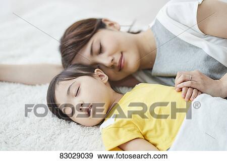 Stock Photo - Japanese mother with sleeping kid. Fotosearch