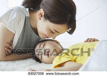 Stock Photograph - Japanese mother with sleeping kid. Fotosearch