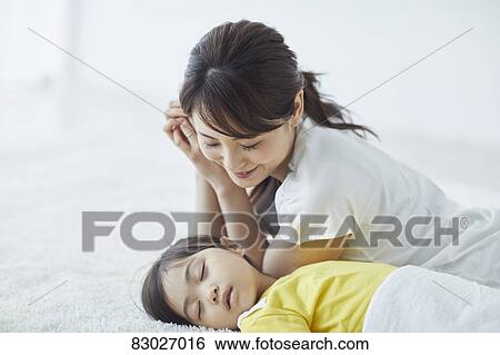 Stock Photograph - Japanese mother with sleeping kid. Fotosearch