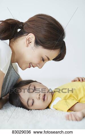 Stock Photograph - Japanese mother with sleeping kid. Fotosearch