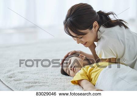Stock Photograph - Japanese mother with sleeping kid. Fotosearch