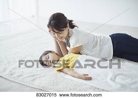 Stock Photography - Japanese mother with sleeping kid. Fotosearch