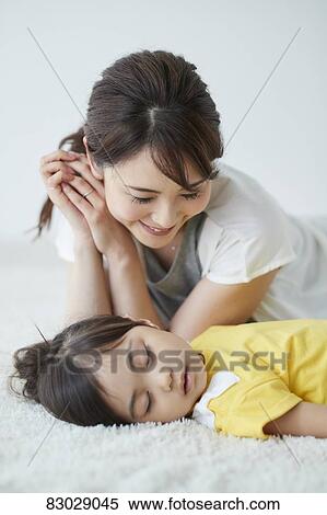 Stock Photography - Japanese mother with sleeping kid. Fotosearch