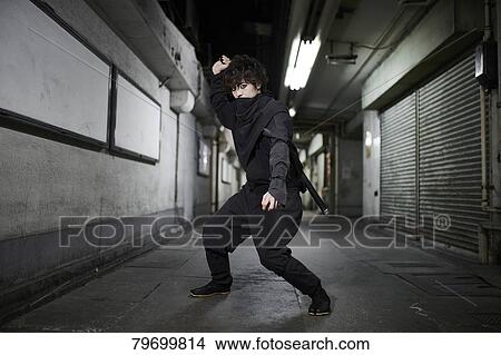 Picture - Japanese ninja at night downtown Tokyo. Fotosearch