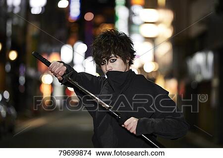 Picture - Japanese ninja at night downtown Tokyo. Fotosearch