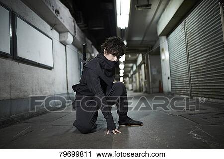 Stock Image - Japanese ninja at night downtown Tokyo. Fotosearch