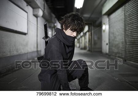 Stock Image - Japanese ninja at night downtown Tokyo. Fotosearch