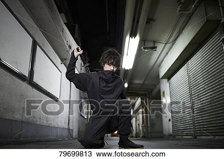 Stock Image - Japanese ninja at night downtown Tokyo. Fotosearch