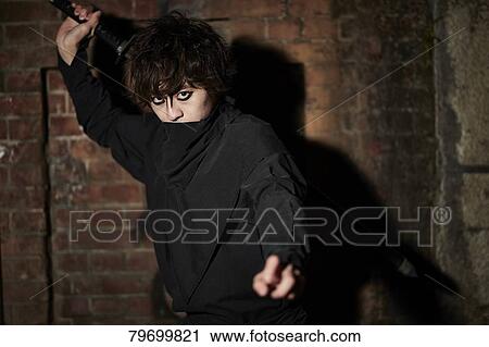 Stock Image - Japanese ninja at night downtown Tokyo. Fotosearch