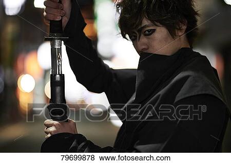 Stock Photo - Japanese ninja at night downtown Tokyo. Fotosearch